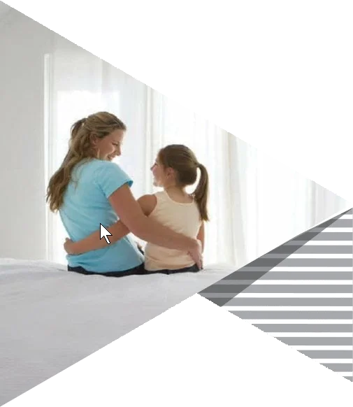 Mother and daughter sitting together in a bright bedroom