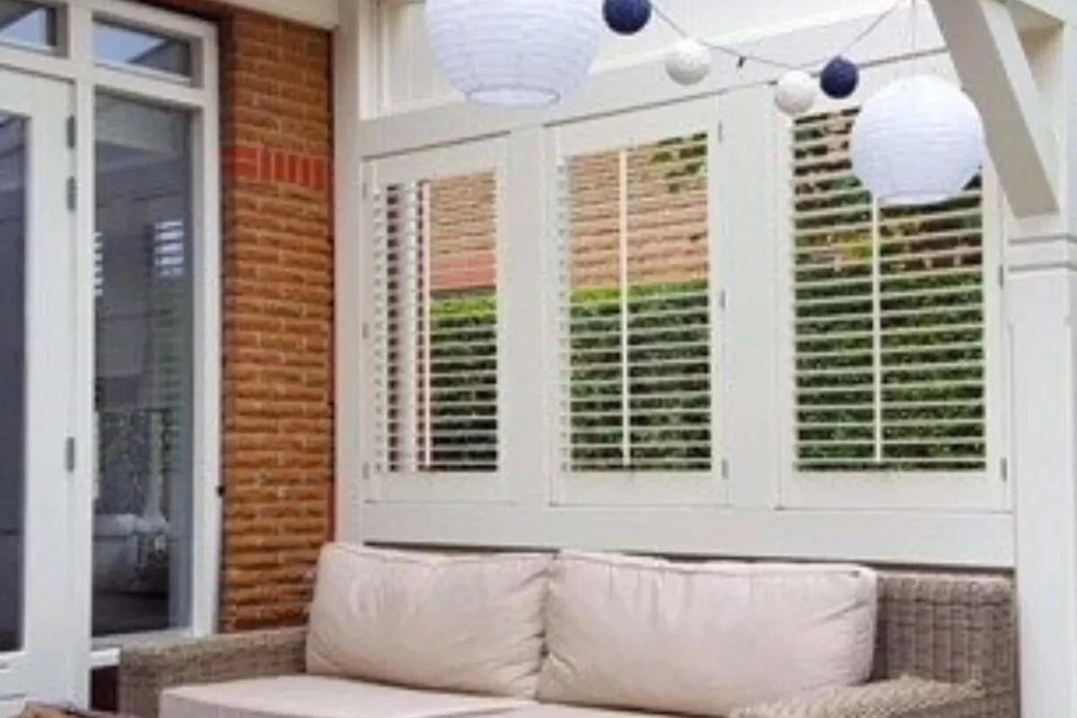 White plantation shutters enclosing a covered patio