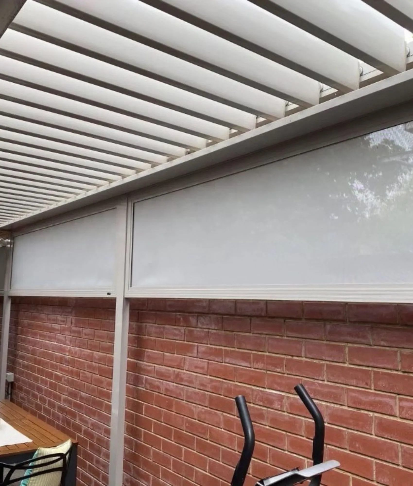 Fixed infill blind under a louvred pergola