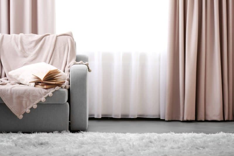 Blush pink curtains layered over sheers in a living room
