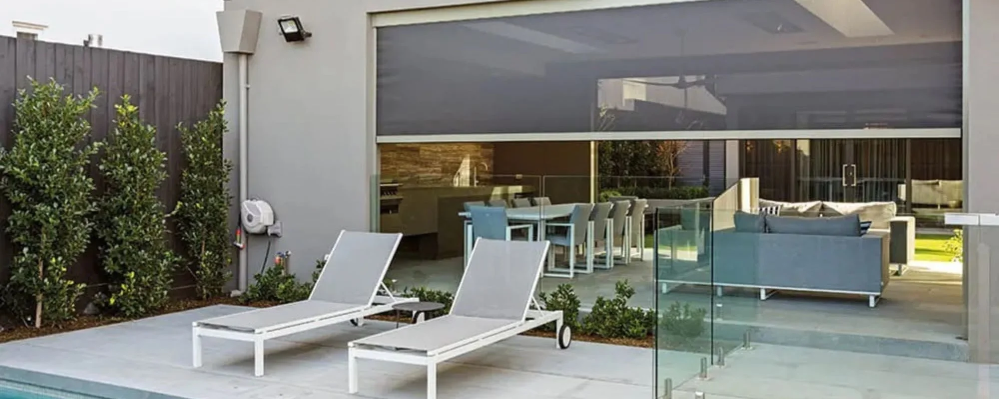 Outdoor blinds lowered around a poolside patio in Adelaide