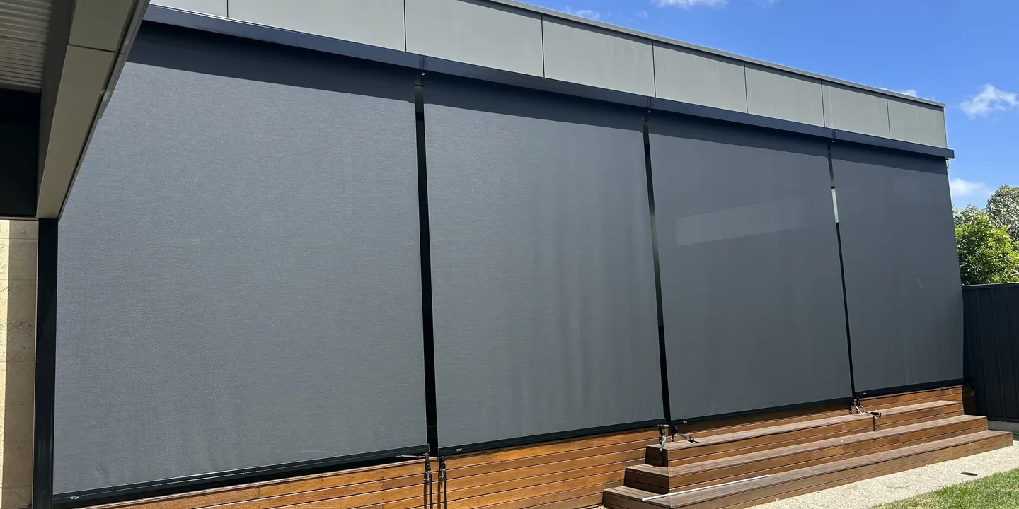 Four charcoal straight drop awnings lowered around a raised timber deck