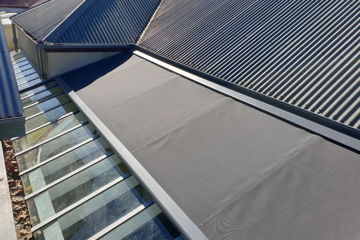 Sundream awning extended across a glass roof, shading the room below