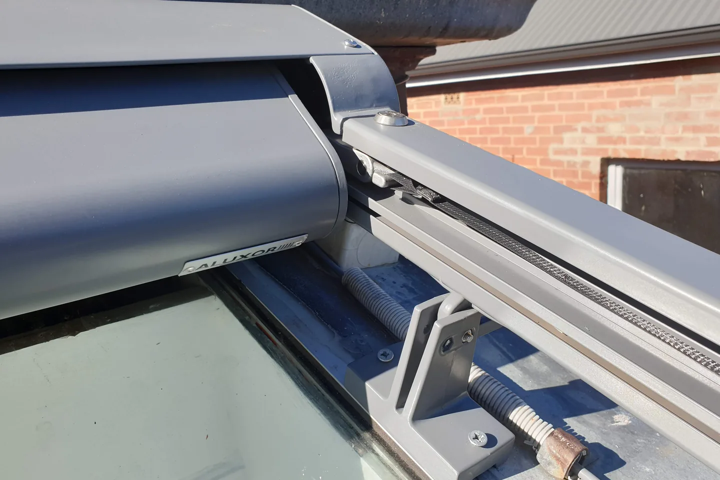 Close view of the Sundream motor housing and side rail mounted on a roof