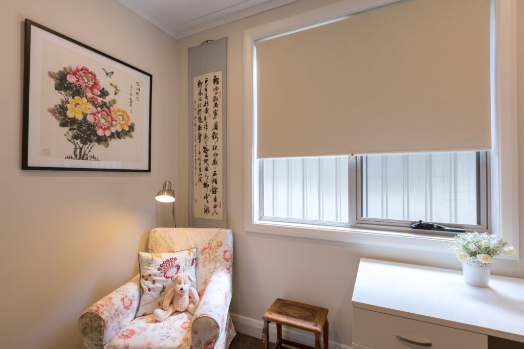 Beige roller blind fitted above a home office window