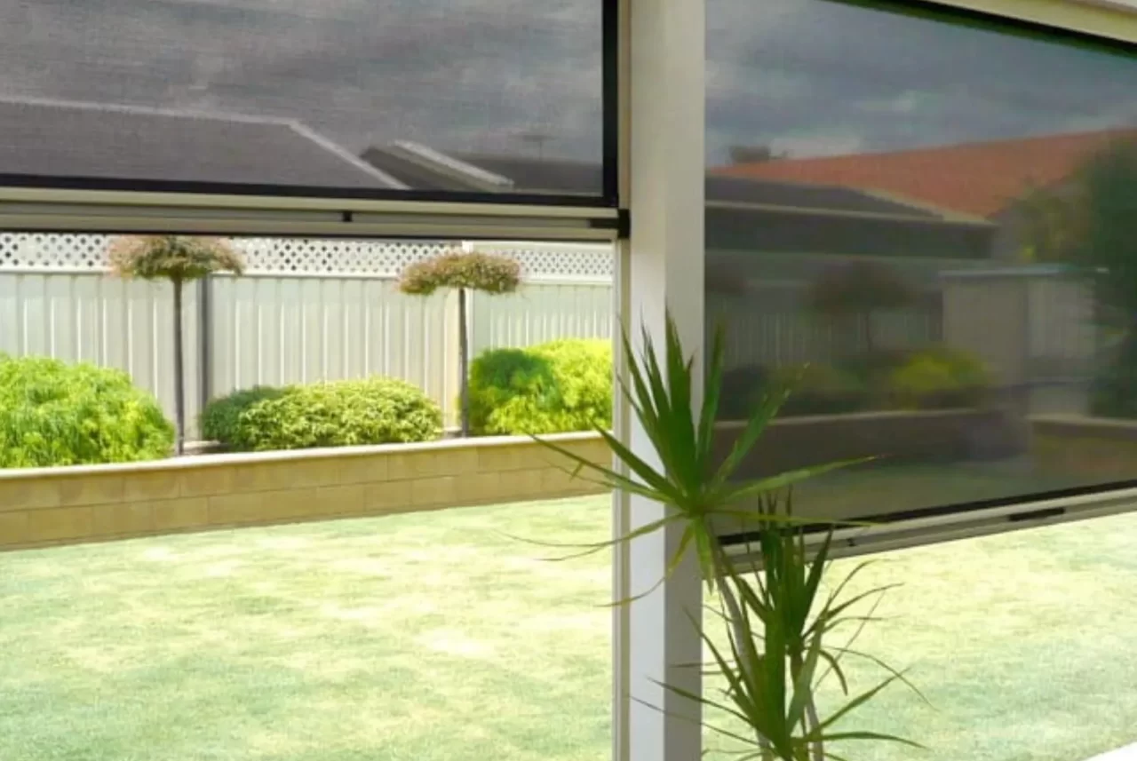View from a patio through a lowered mesh Ziptrak blind, with a second blind raised part-way beside it