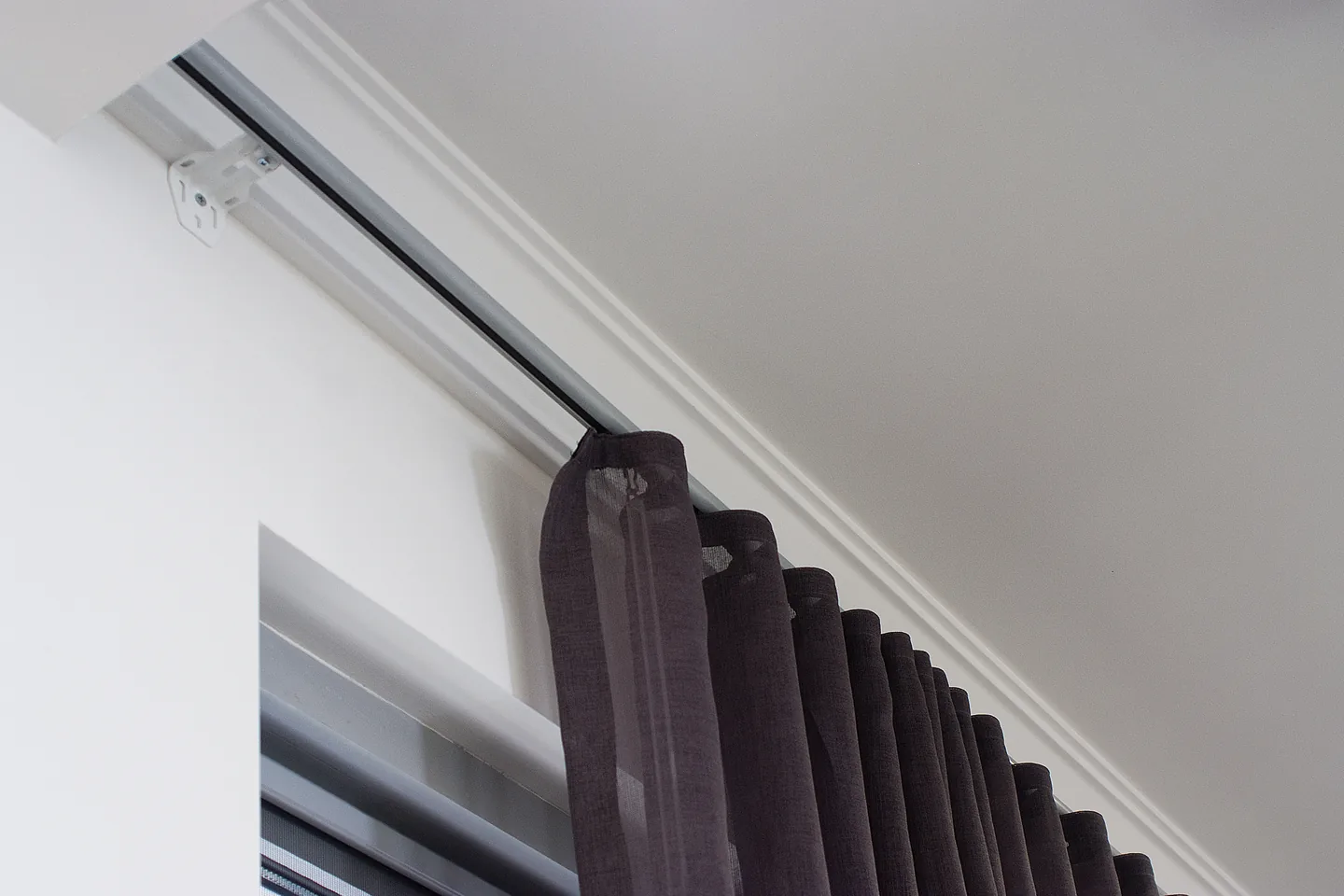 Ceiling-fixed curtain track with the S-fold heading of a charcoal curtain