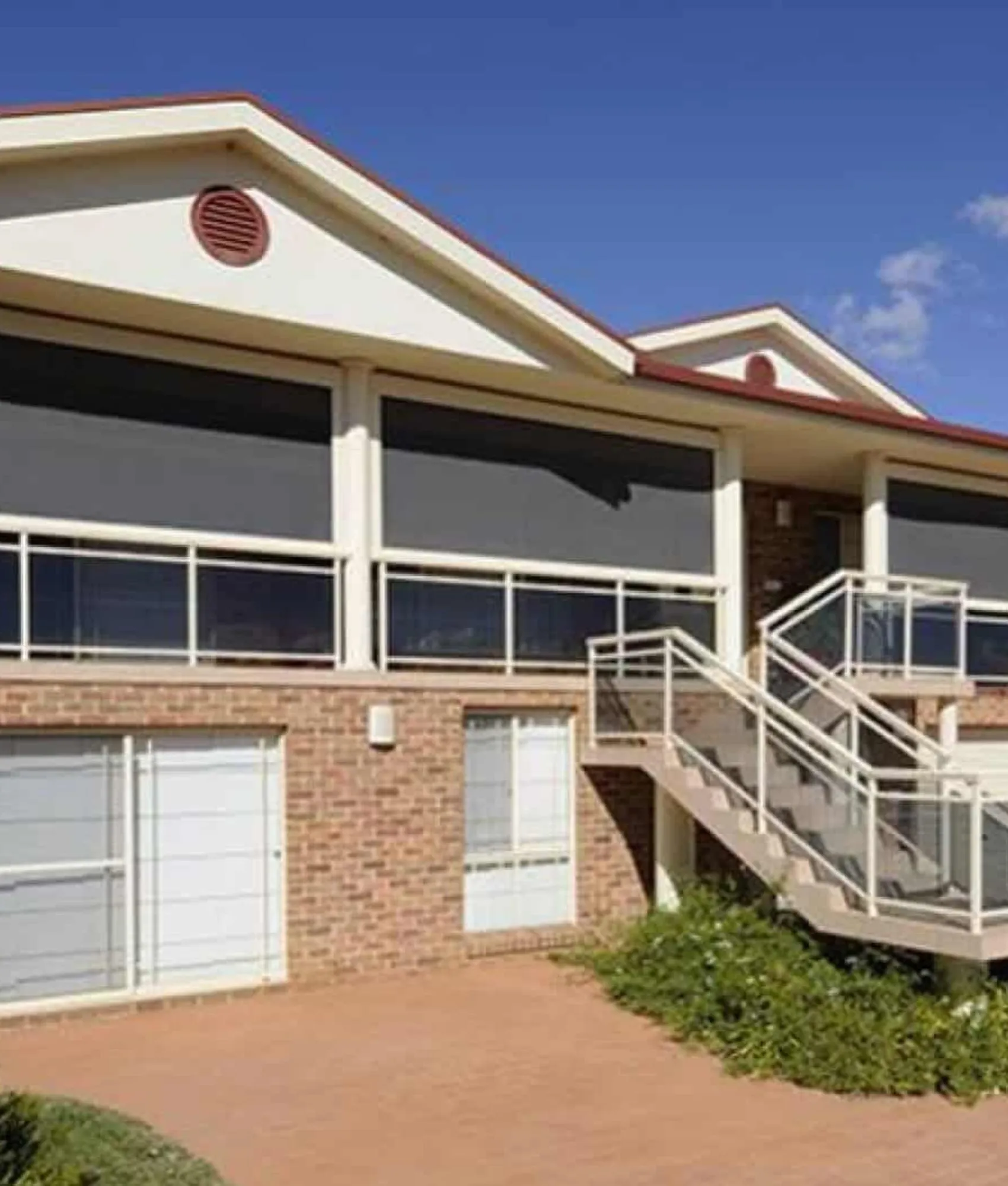 Straight drop awnings on the balcony of a brick home