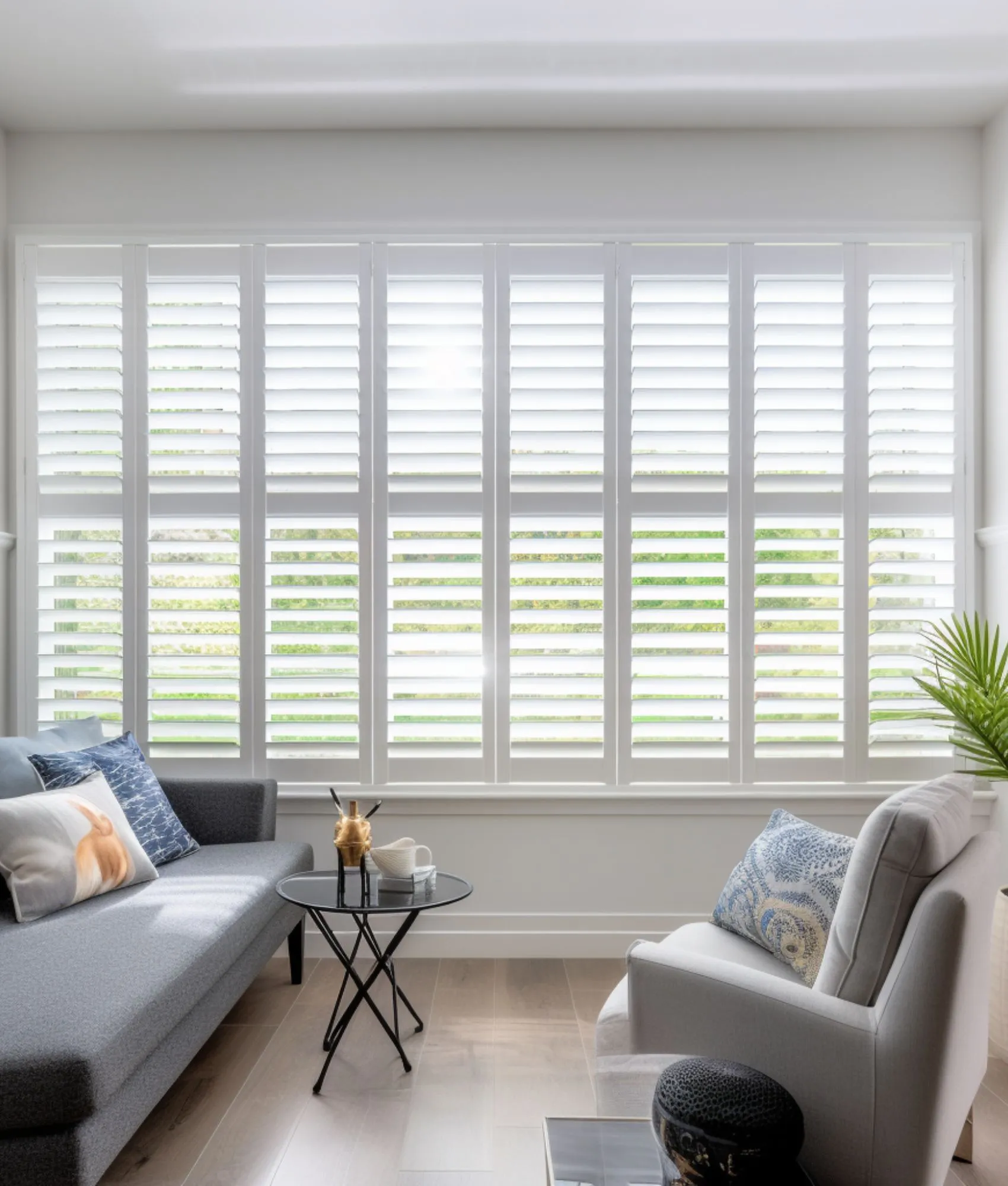 White plantation shutters across a wide living room window