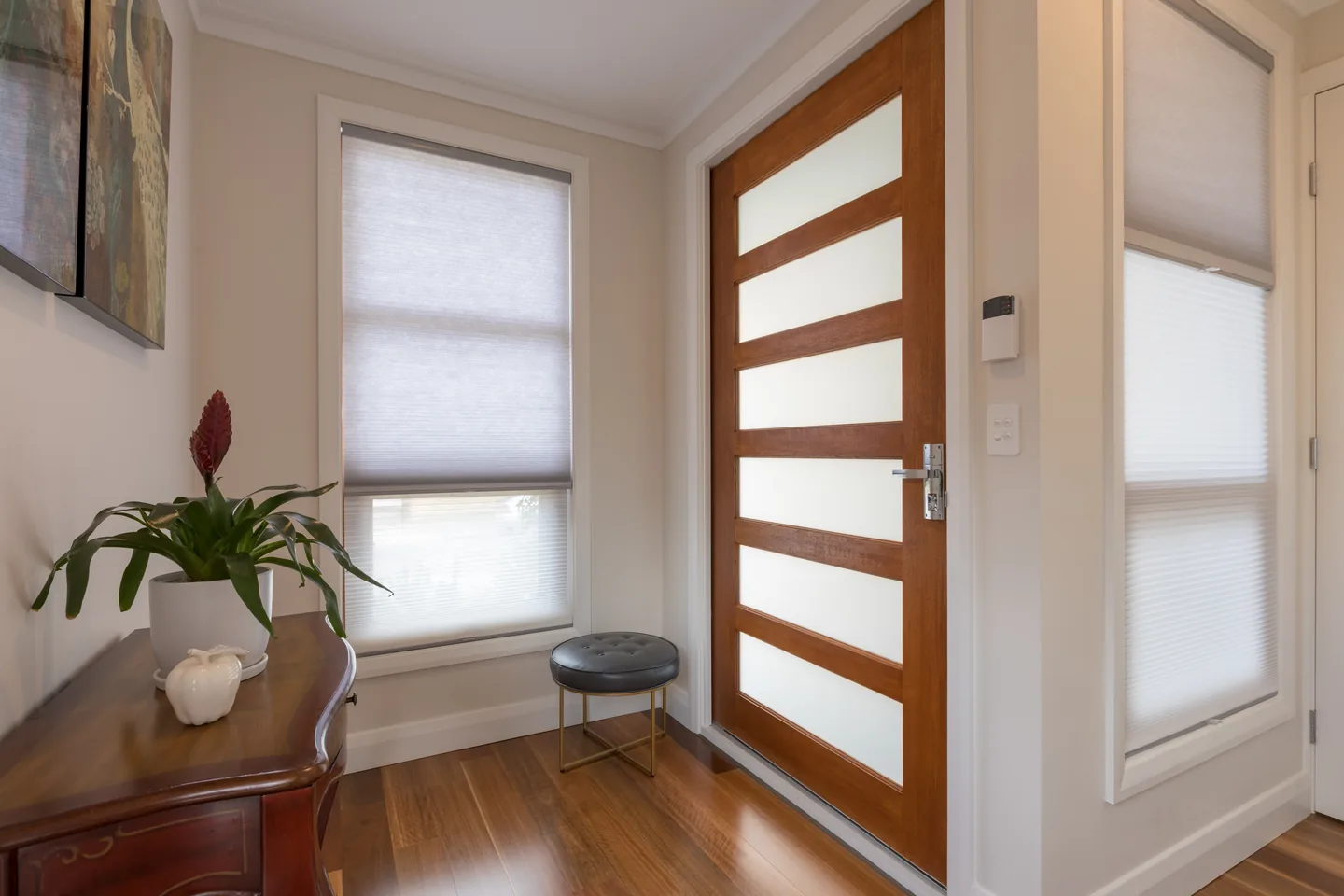 Entry hall with honeycomb blinds on the windows either side of the front door