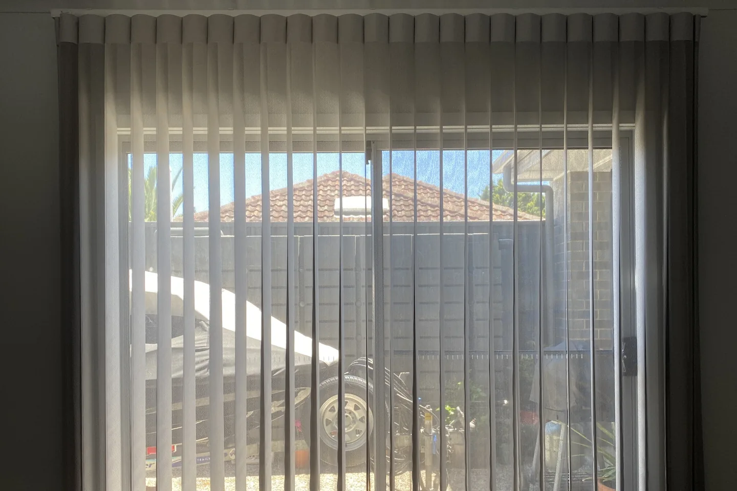 Veri Shades vanes filtering afternoon light at a glass door