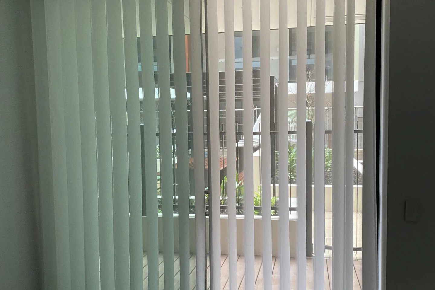 Translucent white vertical blinds across a sliding door, softening the light