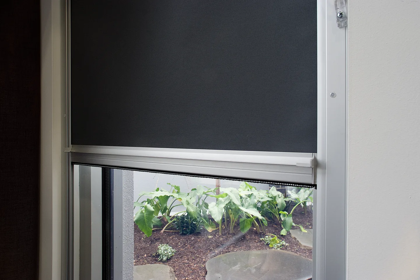 Bottom bar of a charcoal Ziptrak Interior blind running in an aluminium side track