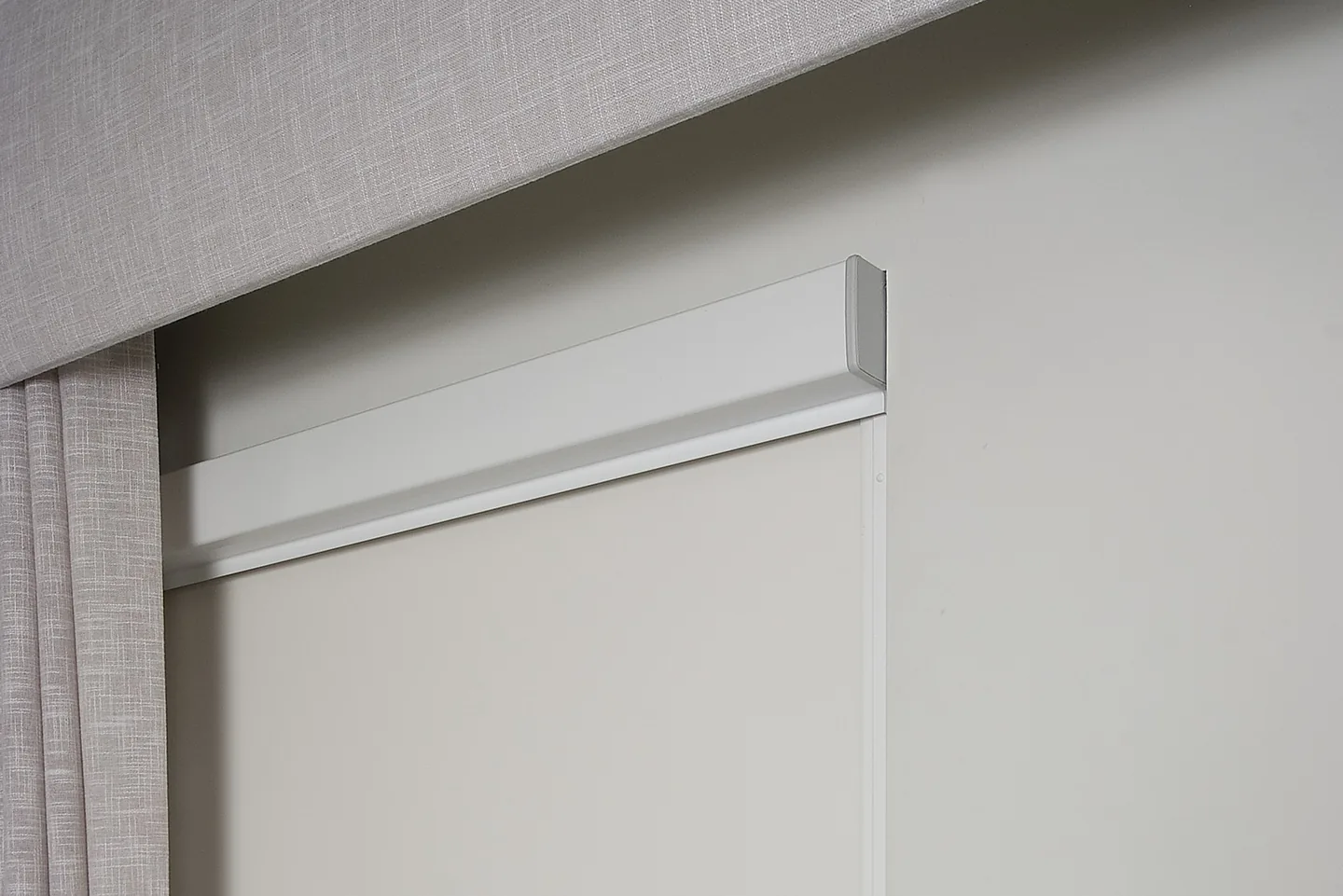 Ziptrak Interior blind lowered in its side track beside a linen curtain