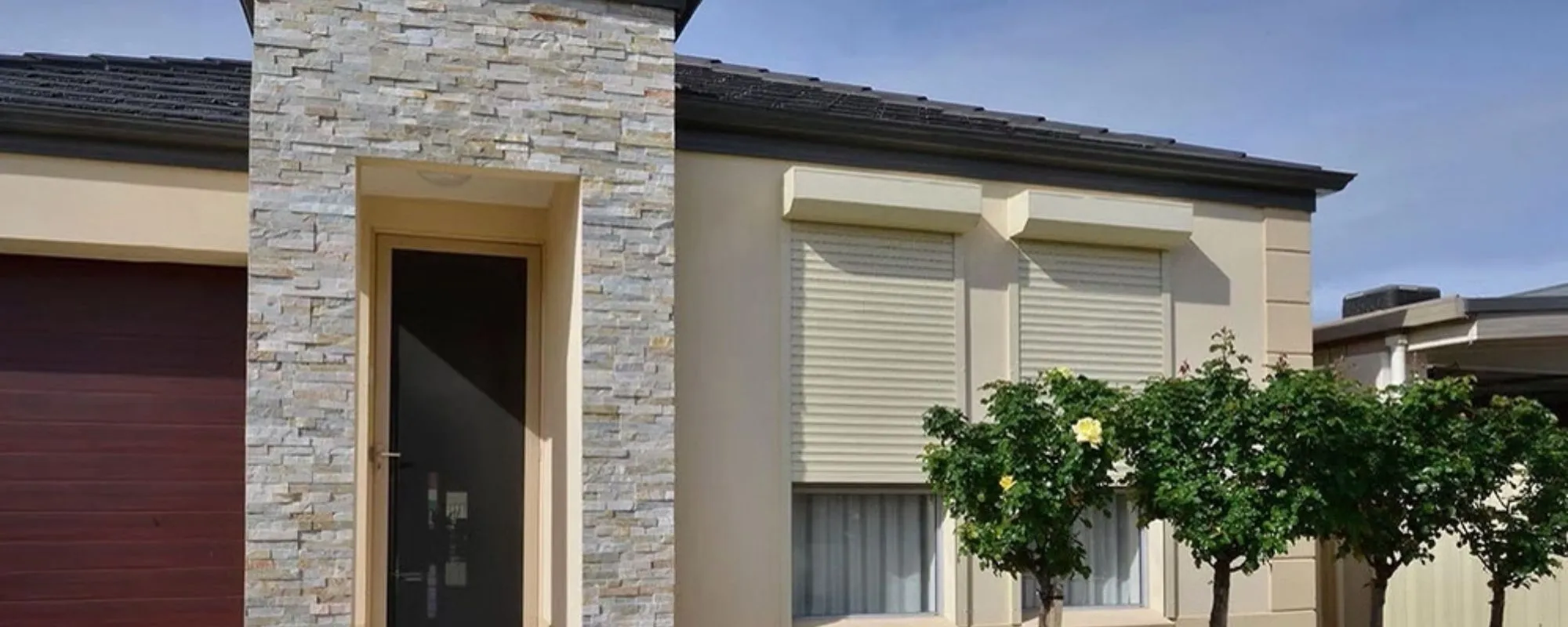 Cream roller shutters on the front windows of an Adelaide home