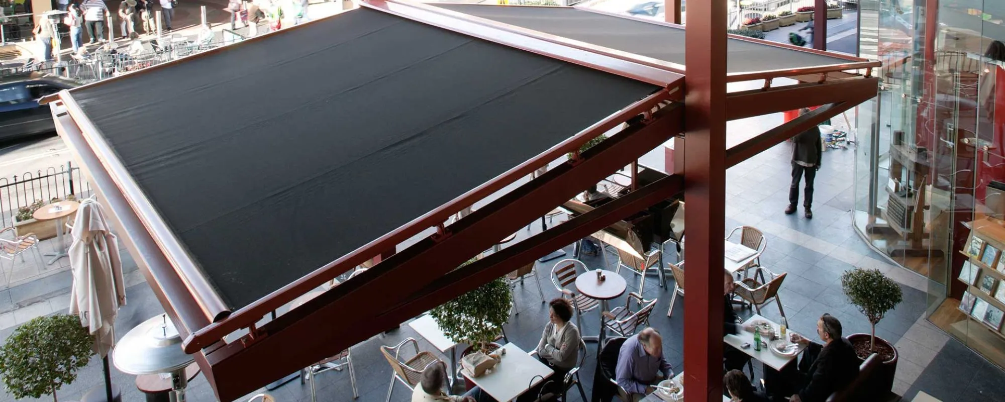 Sundream retractable roof awning over a cafe courtyard