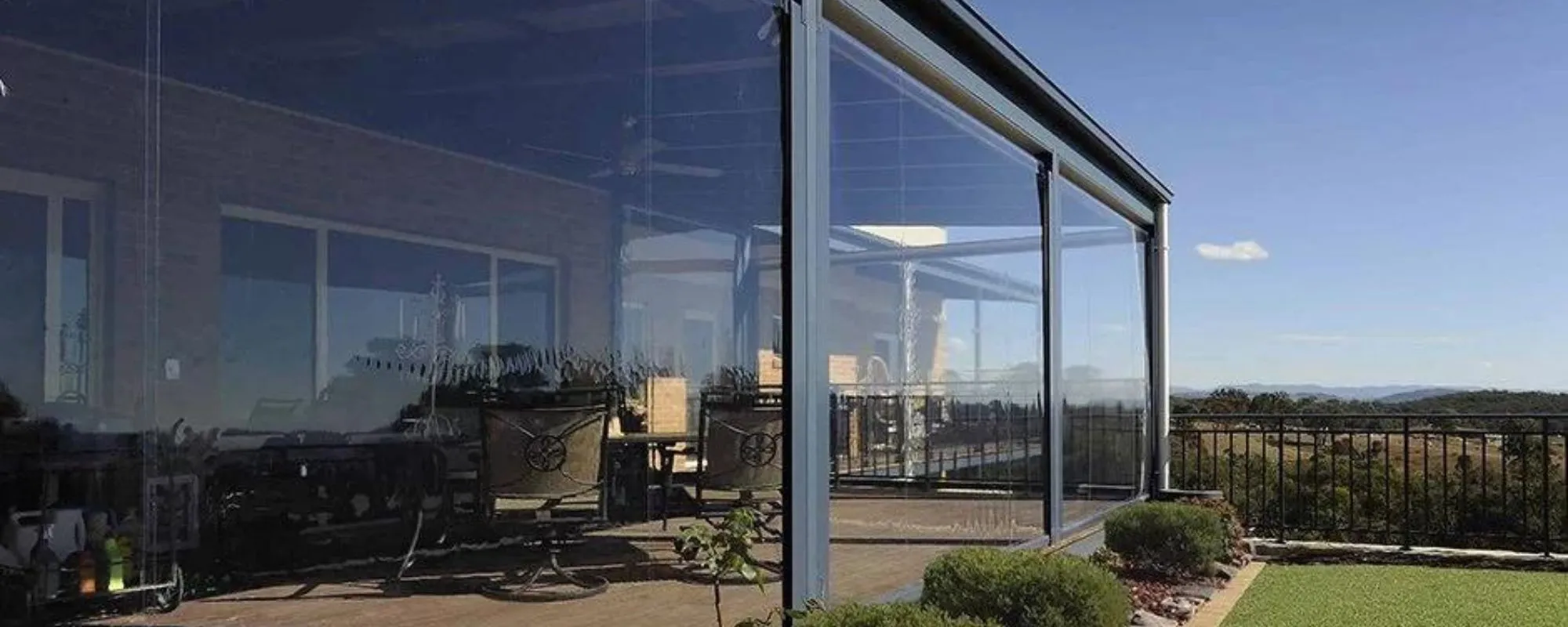 Clear zip roll up blinds enclosing a hillside verandah