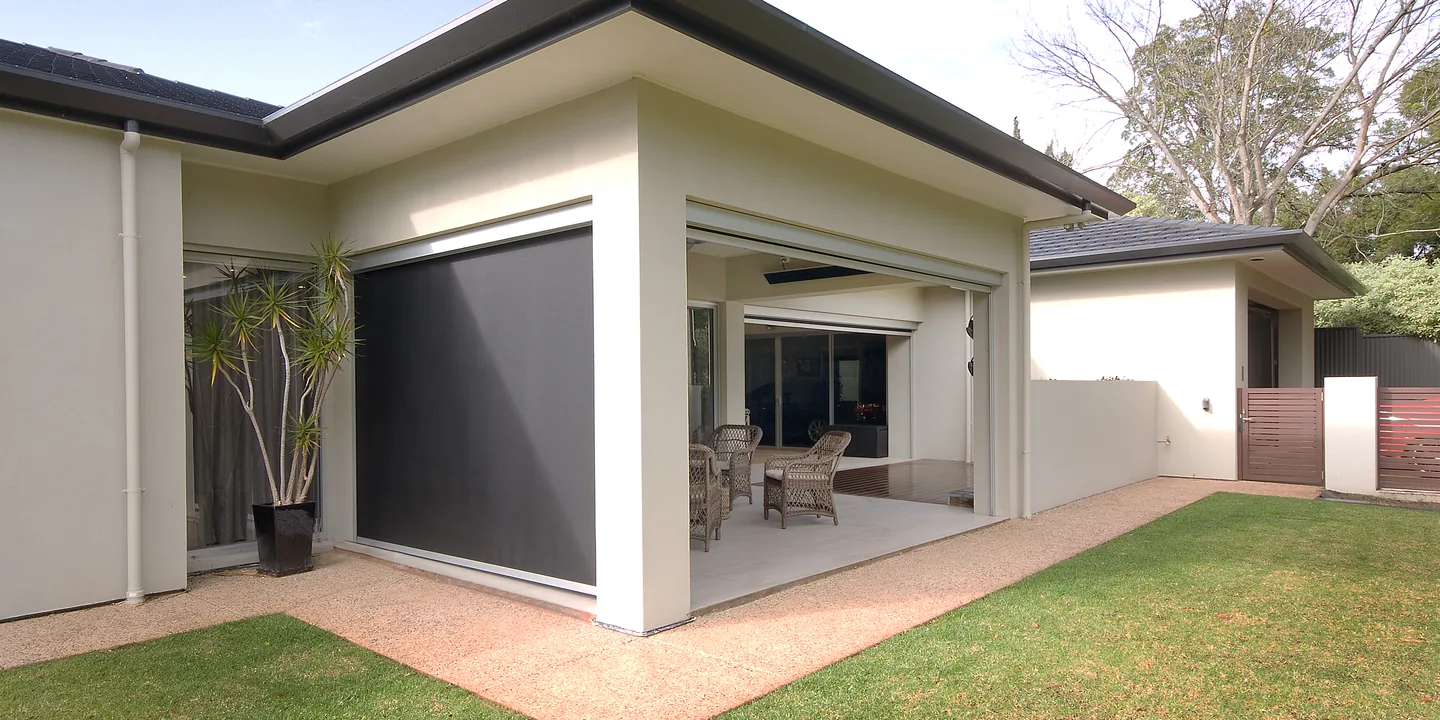 Rendered home with a Zipscreen outdoor blind lowered on one side of the alfresco and raised on the other